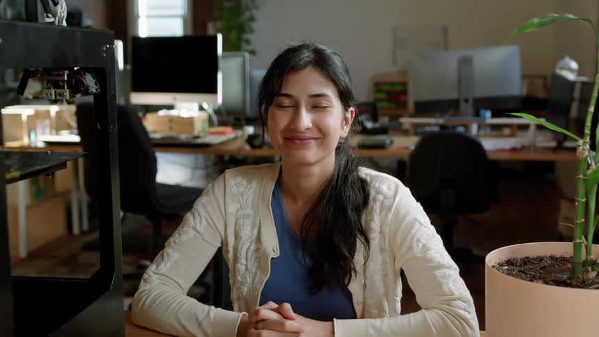 Smiling young woman sitting at desk in office setting