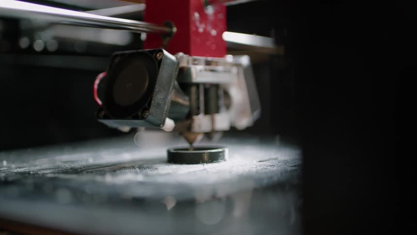 A three dimensional printer moves around an object it is creating