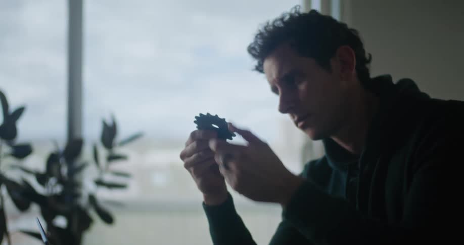 Photographer sitting at desk with laptop examining gears