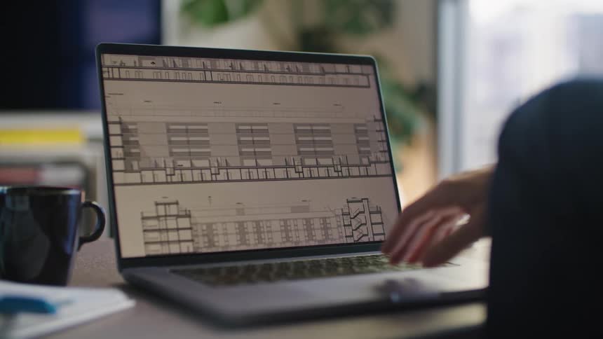 A persons hand and fingers are moving across the touch pad of a laptop computer as they look at an image on the screen