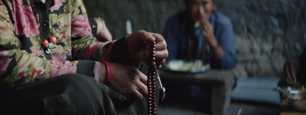 Nepalese Woman with Prayer Beads and Native Man Eating