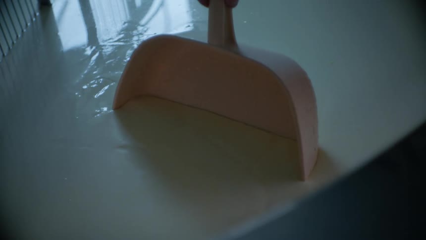 Dipping Hand into Large Vat of White Liquid