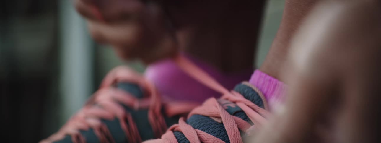 Tying orange shoes laces on womens running shoes