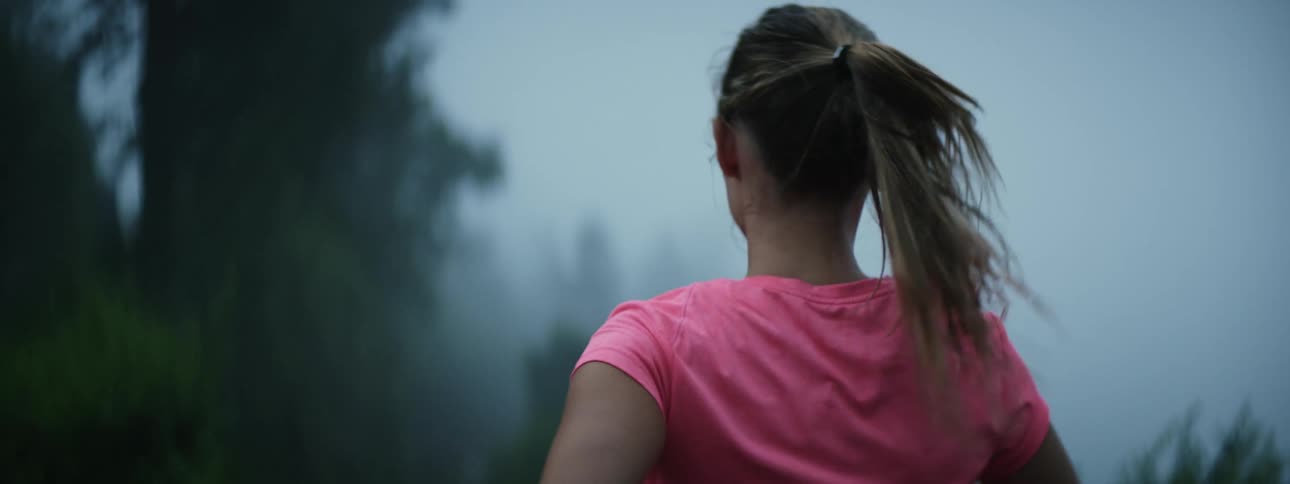 A woman is jogging outdoors during the spring time