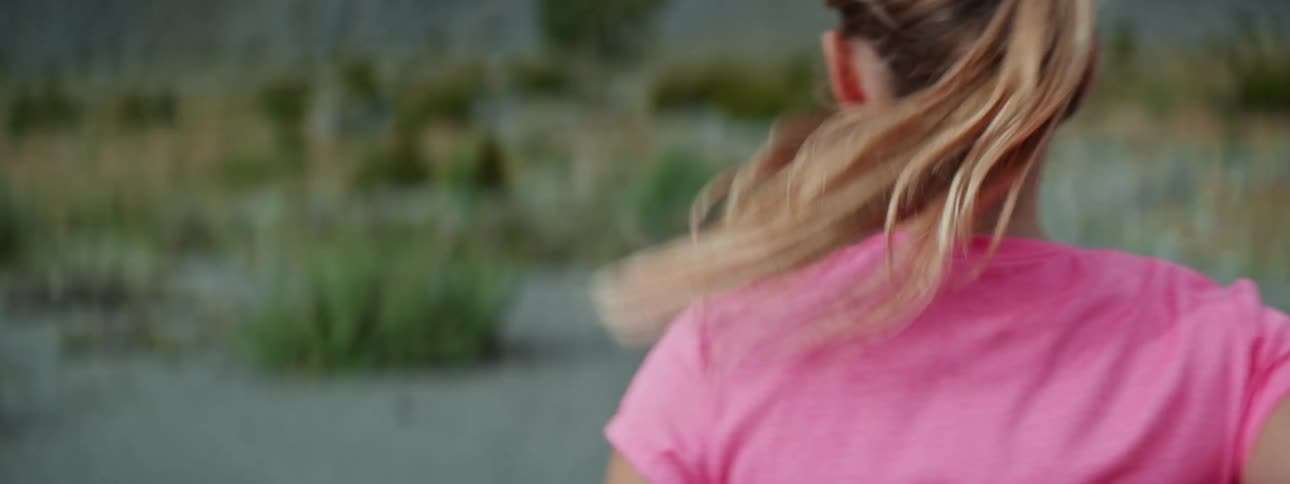 A woman is outdoors and is jogging