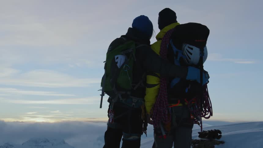 A couple kissing on the top of the snow mountain during sunset