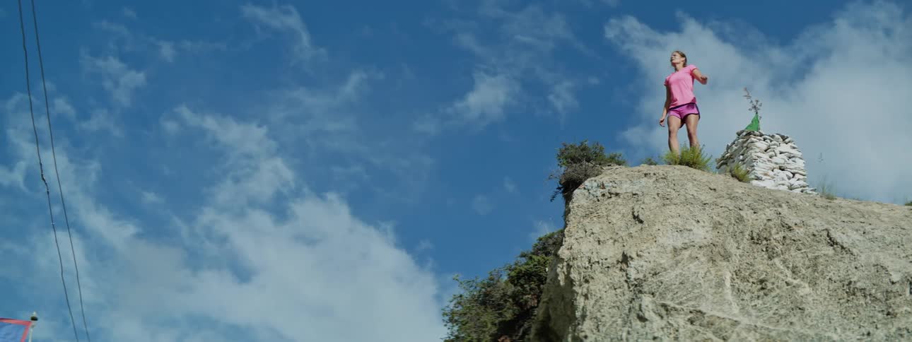 Young Girl's Inspiring Run and Stand on Majestic Mountain