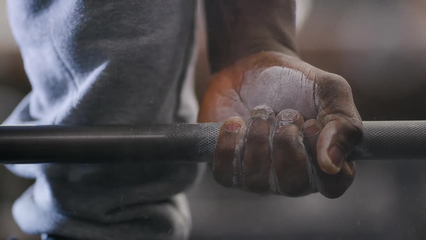 Close up view of a man lifting weights is displayed