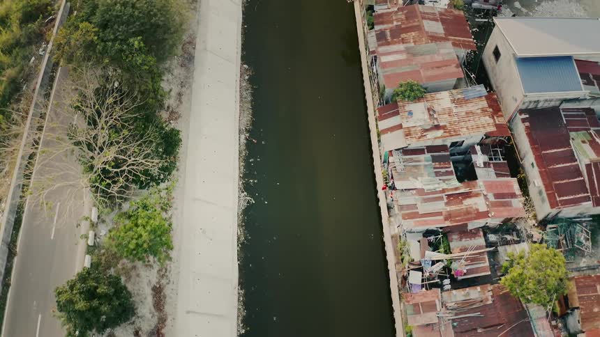 Vehicle drives along highway paralleling river across from homes