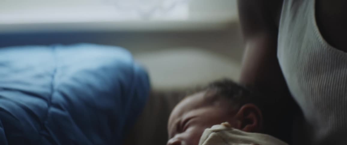 Father in white undershirt holds crying baby