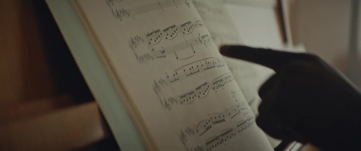 Person reading musical notes set up on a piano