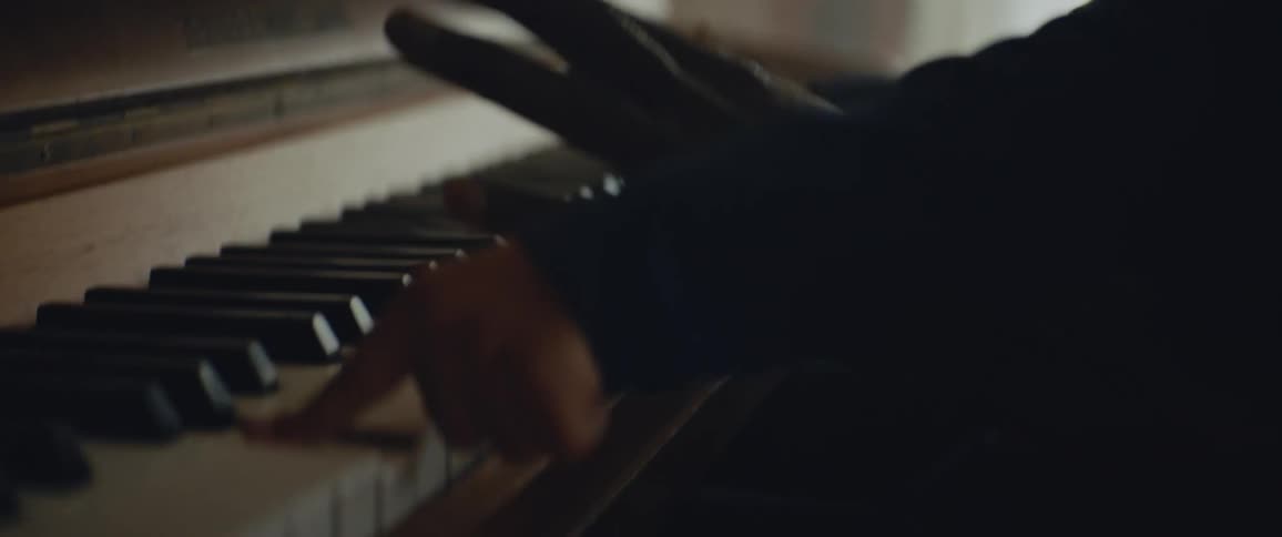 An adult is teaching a child how to play the piano