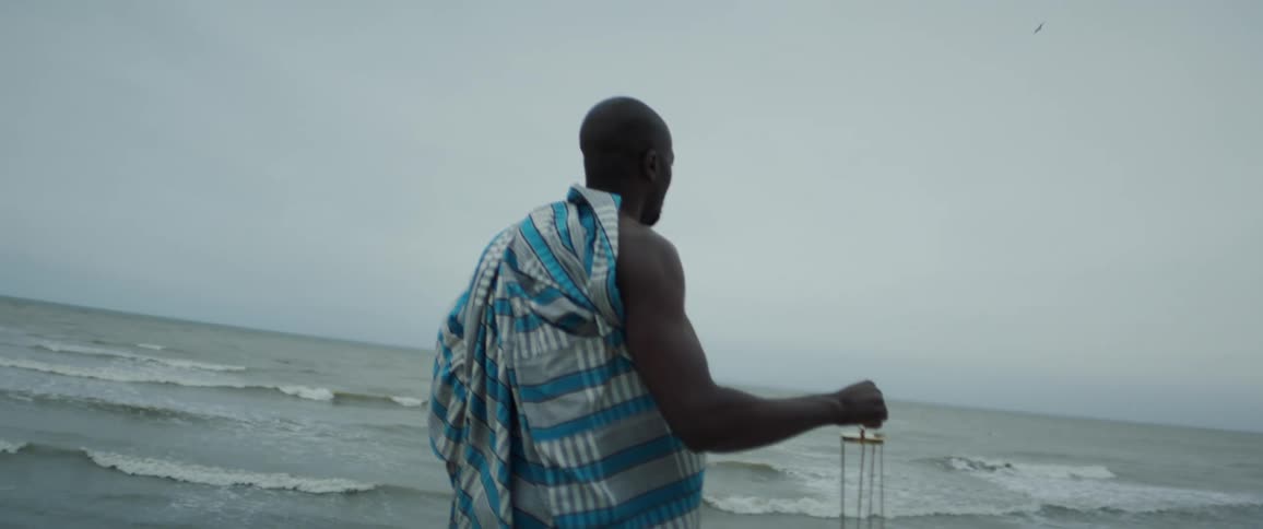 A man is standing at the coast of the beach during midday