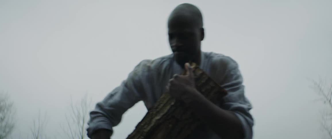 A man grabbing and dragging a wood log struggling and falling to the ground