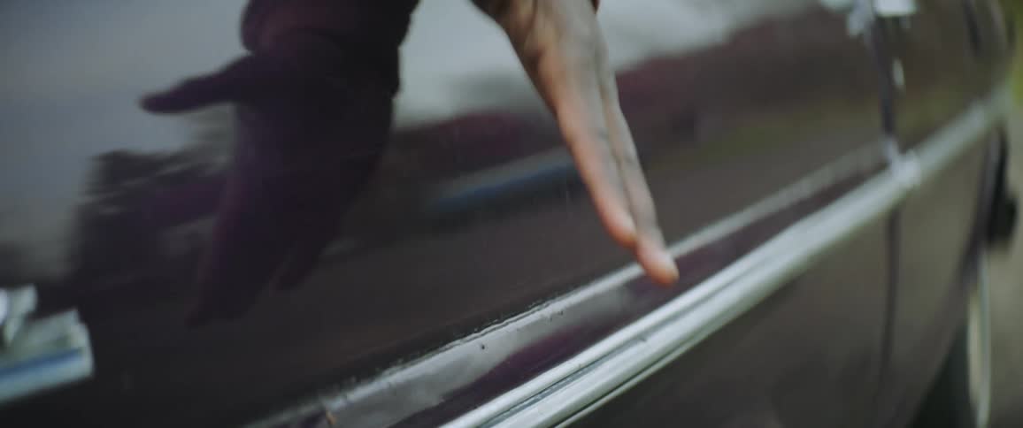 A mans hand is shown patting the door on his truck twice
