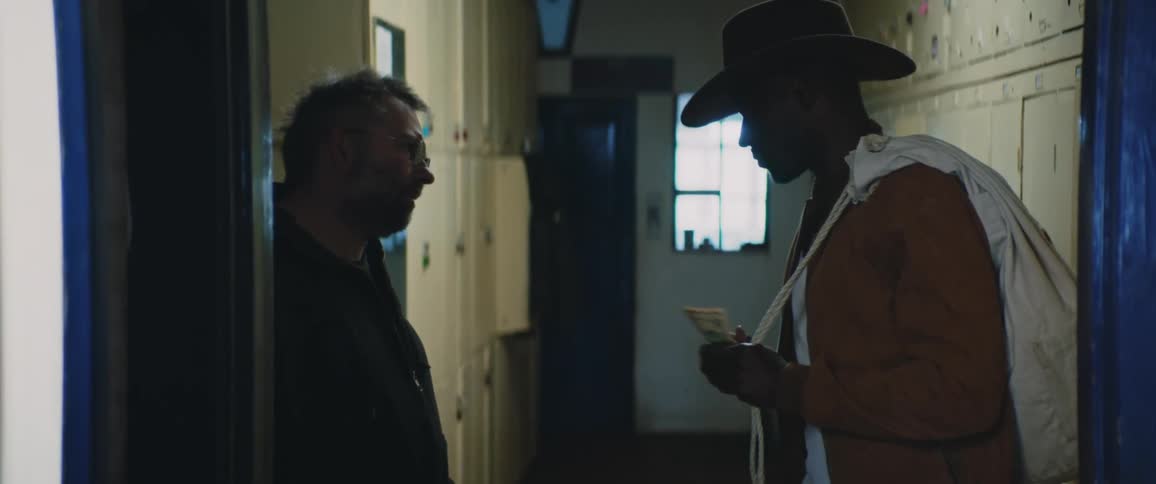 A man is paid then he leaves the hallway