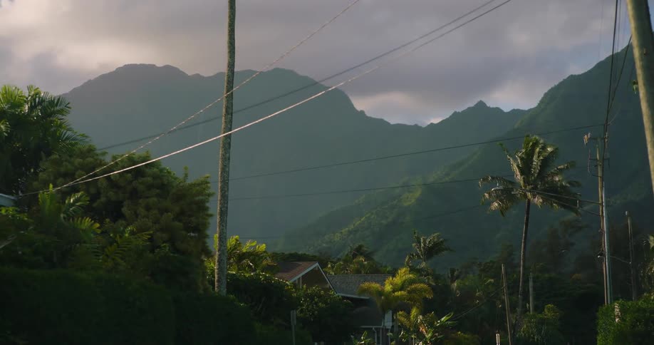 Calm tropical suburb in front of a tall mountain range at evening