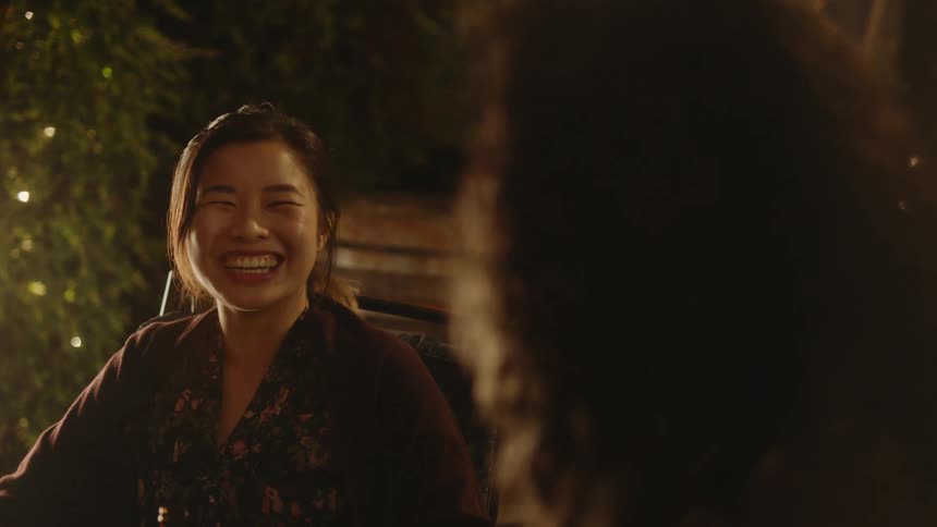 Two women are sitting at a table together and laughing