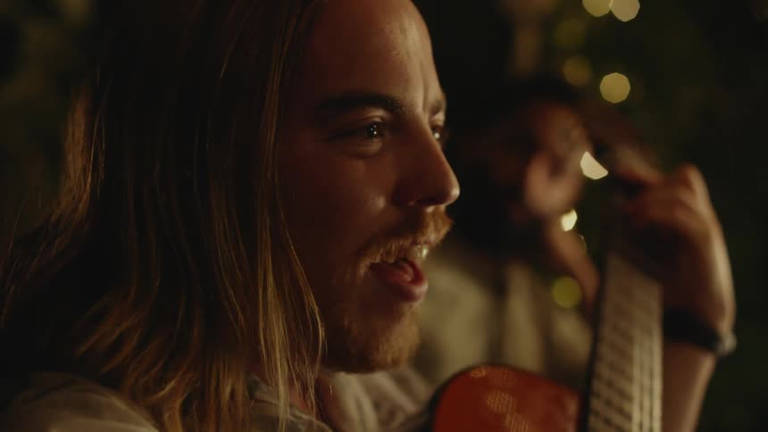 A man is playing an acoustic guitar as he sings