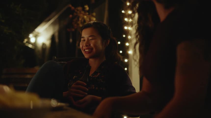 Friends talk and drink at night