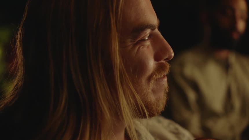 A close up of a mans face nodding slightly and smiling