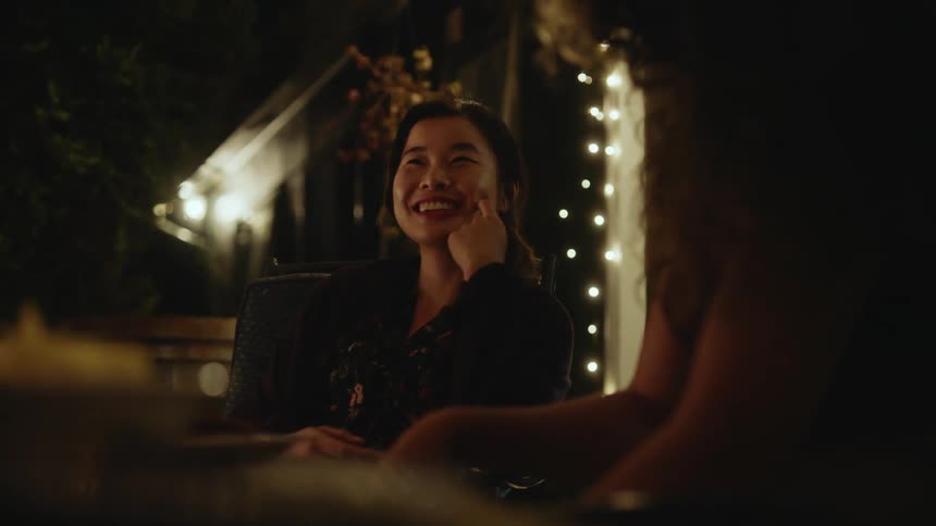 Happy woman sitting on a cozy room smiles while talking to a friend