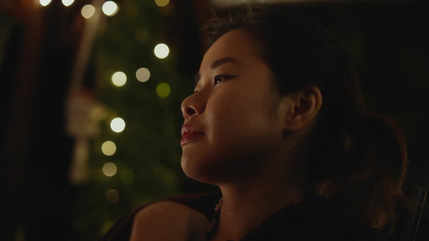 A young girl with a radiant smile on her face lost in deep thought