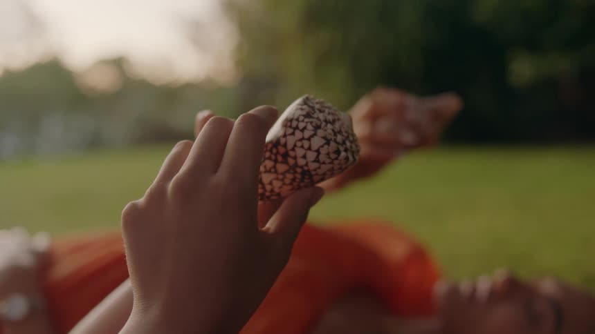 Two women examine objects in their hands