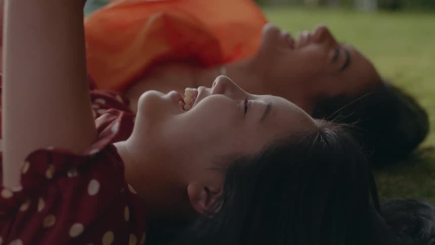Two friends are laughing together on the ground