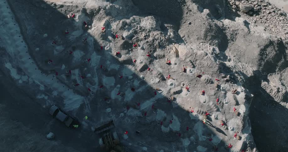 Aeriel view of a crew working in a quarry and a construction vehicle