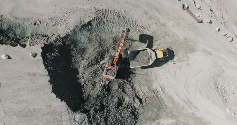 The excavator is putting rocks in the dump truck