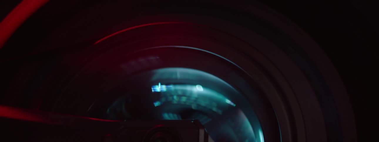 Close up of flashing lights seen through the spokes of a motorcycle wheel driving at night