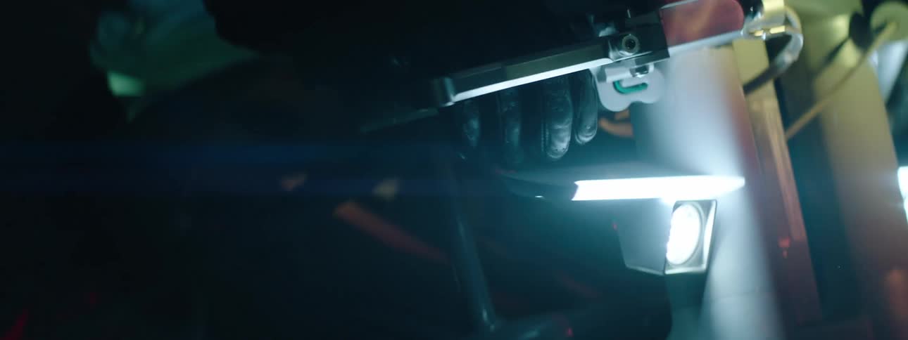 A close up of a persons hand driving a motorcycle with black gloves on