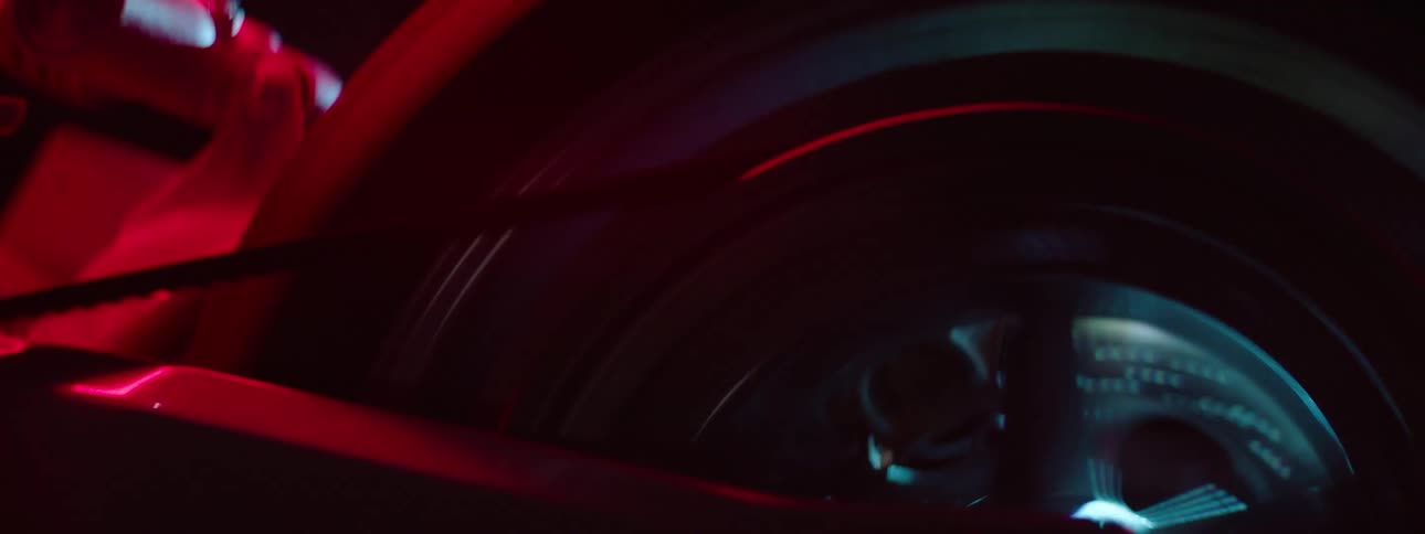 Close up view of a motorcycle driving at night is displayed