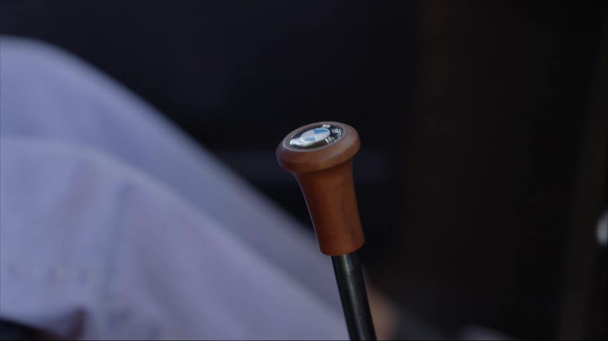 A woman sitting in the drivers seat of a vehicle moves the gear shift and hits the gas pedal with her foot
