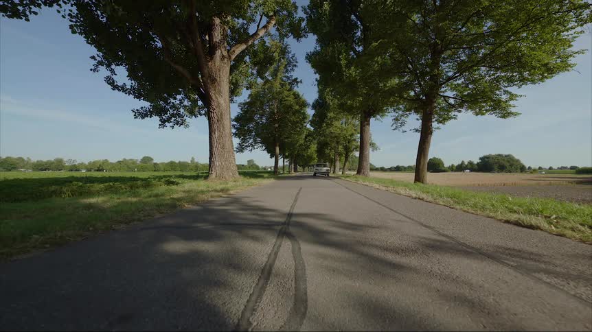 Old classic white car drives on country road