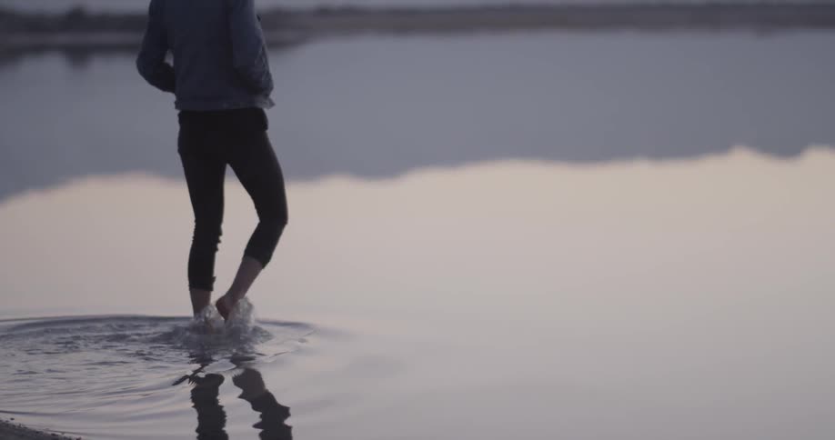 A woman walks into a lake of water