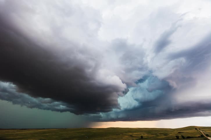 Dark storm clouds gather in the sky over the field