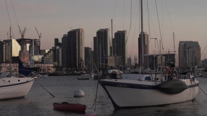 Boats are docked near a city at sunset