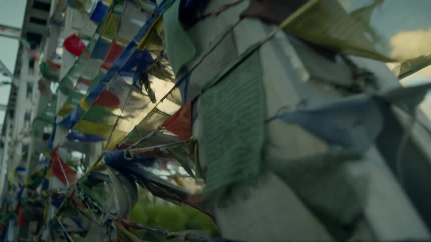 Wind blows through flags on banners attached to a bridge