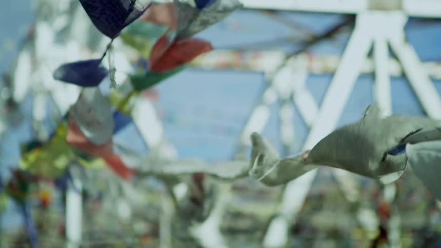 Banners of different colors flutter on lines strung from open air structure
