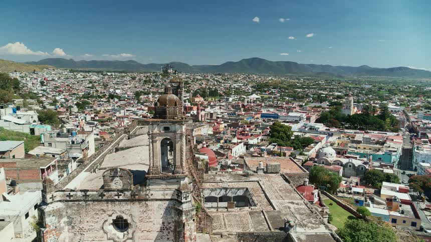 Landmark cathedral has two towers and sits on hill above sprawling town spreading between hills