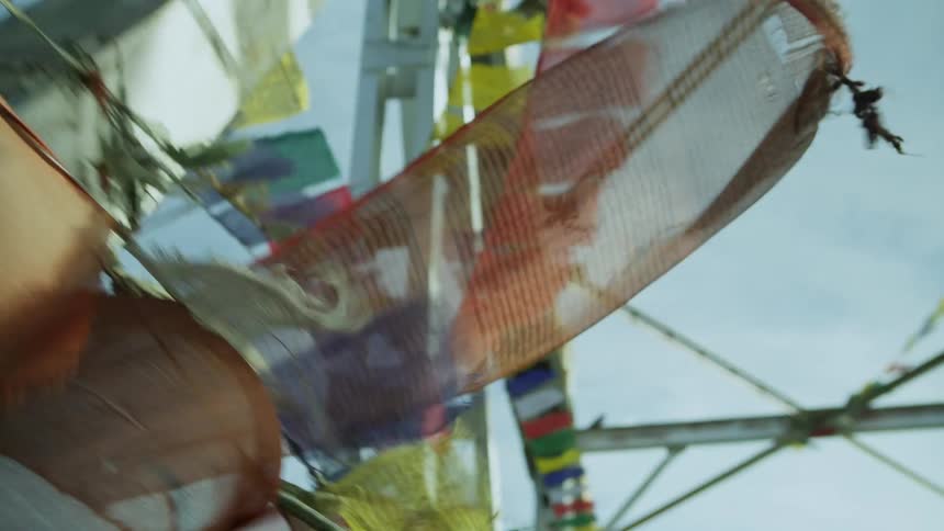 Colorful flags hang from string on a bridge