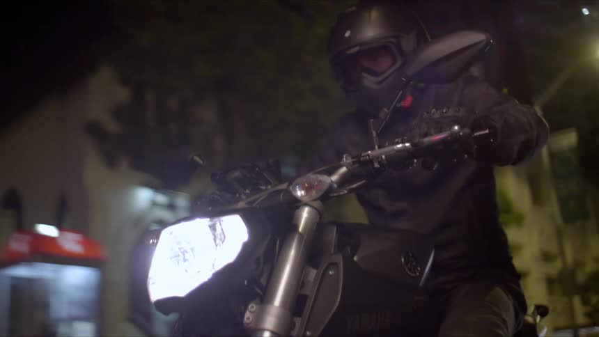 A person riding a motorcycle outdoors at night