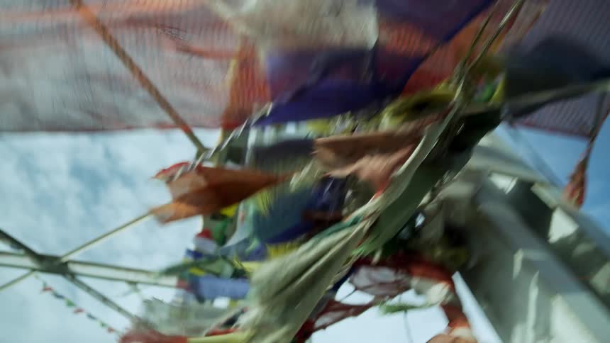 An array of colorful square clothes flap in a strong breeze