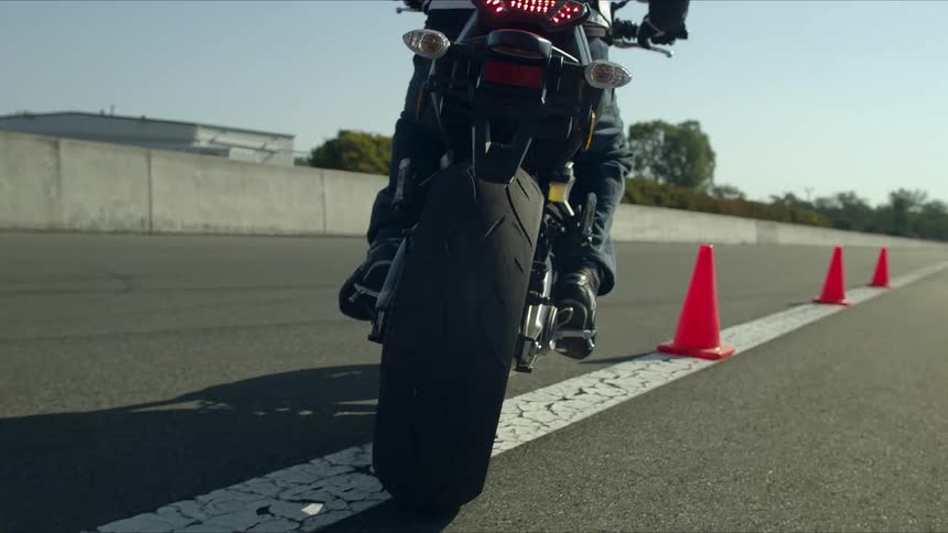 A person riding a motorcycle between cones