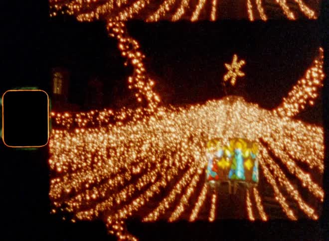 Thousands of small LED lights on light chains illuminate the dark night sky over a town square surrounded by houses and buildings on a traditional Christmas market or fair with a bright star symbol on a cold winter evening during advent time