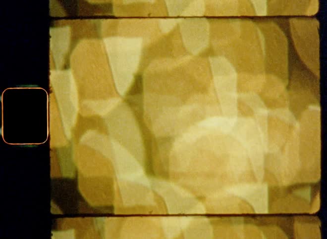 Various square bokehs move down due to upward camera motion created by gold colored light chain of a Christmas tree as an abstract transition or moving texture filmed with old handheld dynamic Super 8mm film camera