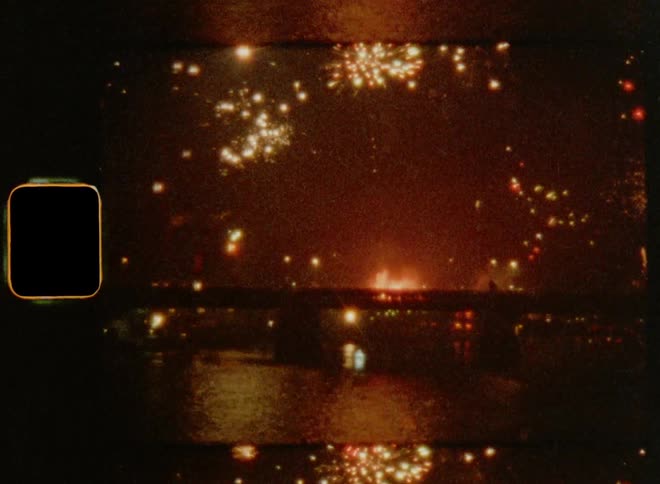 Fireworks going off over the sea at night