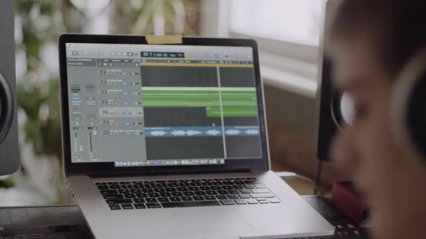 A woman is wearing headphones in front of a laptop